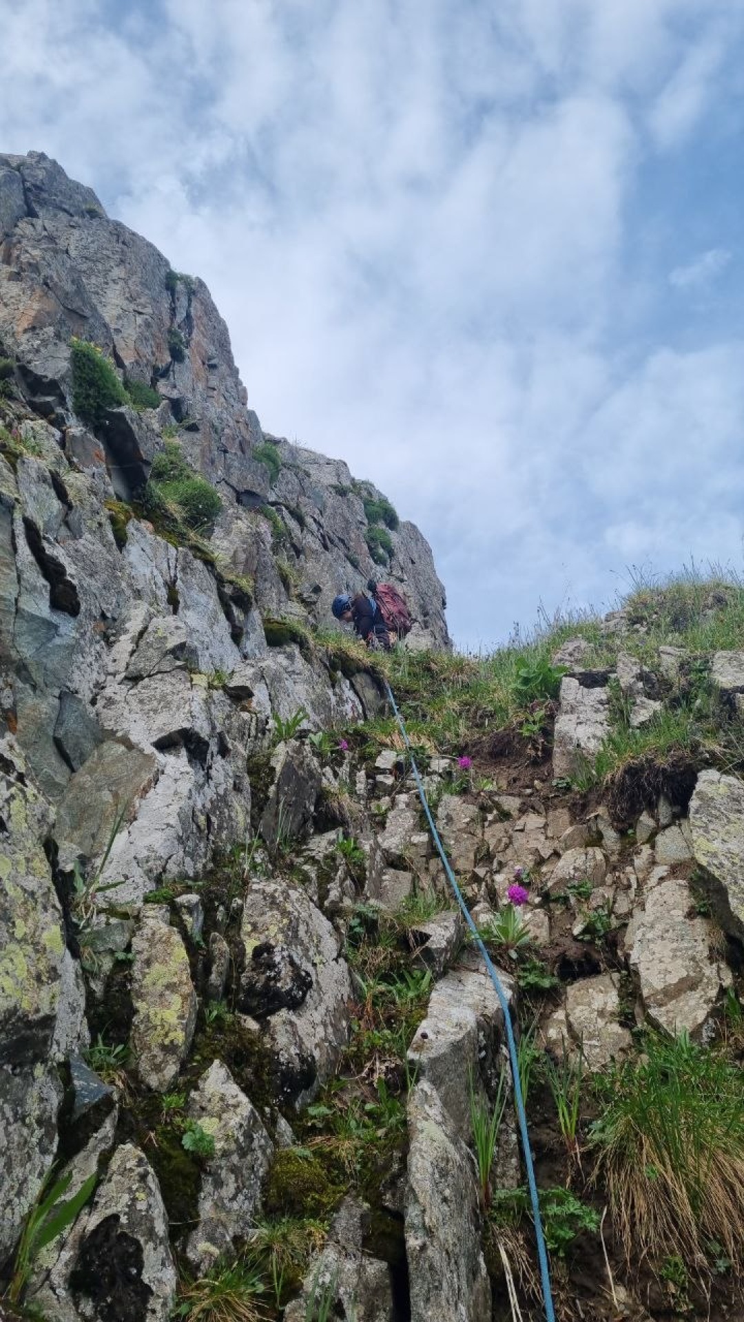 Climber leads a rock pitch in the mountains